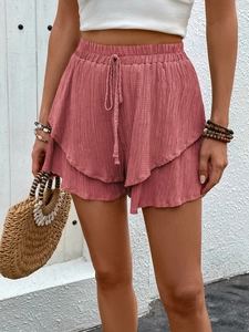 Detailed texture of high-waisted brick pink shorts with elastic drawstring and tiered ruffle hem
