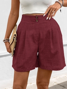 Detail von weinroten Leinen-High-Waist-Shorts mit Zierknöpfen und Faltenwurf