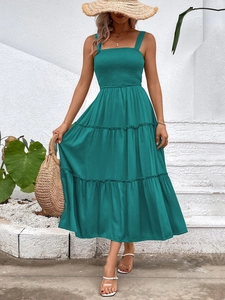 Detail of smocked square neck bodice and tiered skirt on dark green summer midi dress