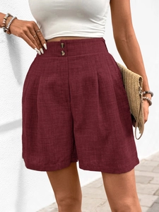 Detailaufnahme der weinroten High-Waist-Plissee-Shorts mit dekorativen Doppelknöpfen am Bund
