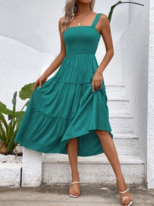 Close-up of emerald green tiered summer dress with smocked bodice and square neckline