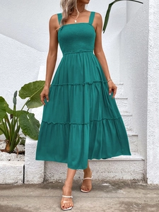 Detailed view of dark teal smocked bodice and tiered ruffle skirt on summer dress