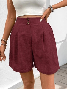 Nahaufnahme der dunkelroten Leinen-Shorts mit hohem Bund, Doppelknöpfen und Falten-Detail