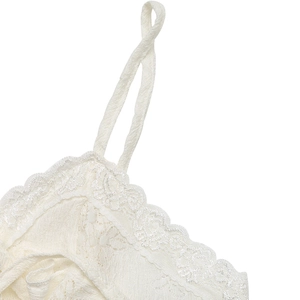 Macro shot of ivory knit top showing vertical texture and delicate lace trim details