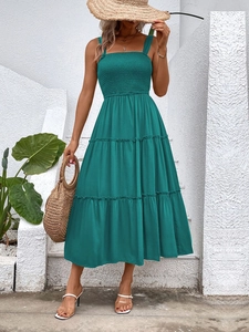 Detail of teal sleeveless tiered sundress with a smocked bodice and layered skirt