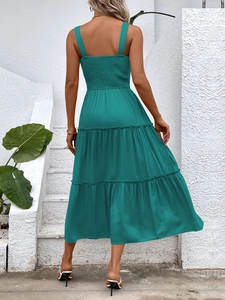 Detail view of the back of a teal blue tiered sundress with smocked elastic fabric design