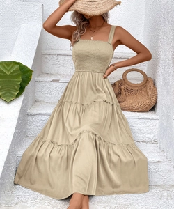 Detail of smocked chest design and tiered skirt on a beige summer vacation maxi dress