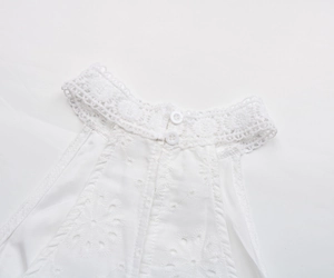 Détail de la robe dos nu blanche avec broderie florale et col en dentelle crochet