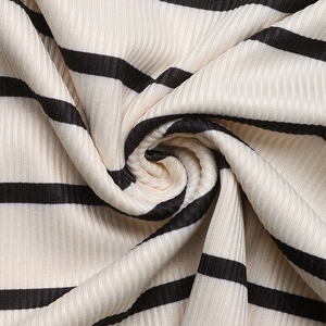 Détail macro du tricot côtelé à rayures noires et crème pour hauts d'été à épaules dénudées