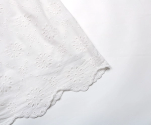 Détails de broderie anglaise florale blanche et ourlet festonné d'une robe d'été légère