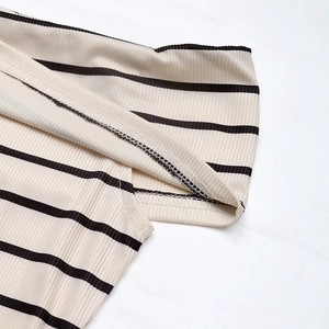 Détail du tissu en maille côtelée à rayures beiges et noires avec des coutures précises