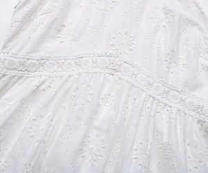 Détail de la broderie anglaise blanche et de la dentelle au crochet sur la robe d'été