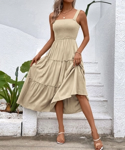 Detailed view of the smocked bodice and wide straps on a light khaki tiered dress
