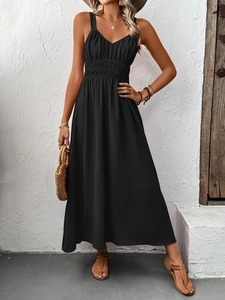 Detail of black bohemian maxi dress featuring high waist smocking and pleated fabric texture