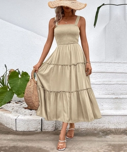 Detail view of smocked bodice and tiered hem on this beige summer midi dress