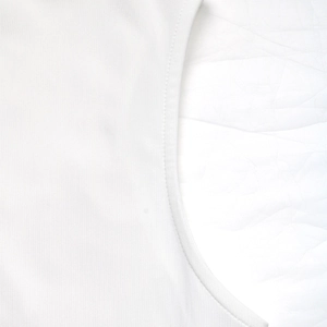Detailed macro shot of fine stitching and seams on white cotton blend sleeveless dress