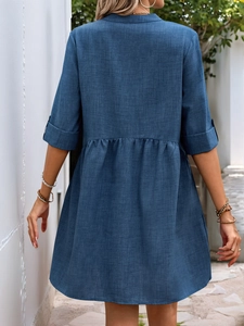 Rear view of a navy blue V-neck dress showing fine fabric texture and high-waist pleats