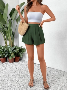 Détail du short taille haute vert foncé à jambes larges avec bouton et plis élégants