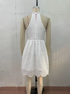 Vue détaillée du dos de la robe en dentelle blanche avec broderie florale et ourlet ondulé