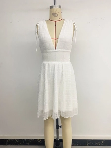 Detail of V-neckline and shoulder bow ties on a white smocked waist mini summer dress