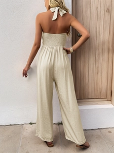 Detail of smocked back and halter neck on a beige loose sleeveless summer jumpsuit