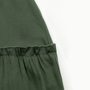 Detail of army green fabric featuring ruffled stitching and textured cotton blend weave