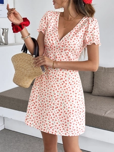 Détail de la robe d'été à col en V avec manches bouffantes et motifs floraux rouges