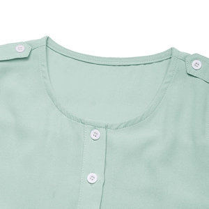Détail de l'encolure de robe en mousseline vert menthe avec petits boutons blancs