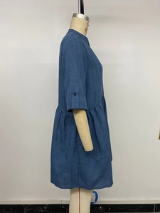 Detail of blue cotton-linen shirt dress featuring pleated waist and buttoned mid-sleeves