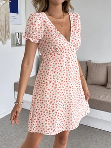 Détail de la robe courte fleurie avec col en V, manches bouffantes et motifs de fleurs rouges