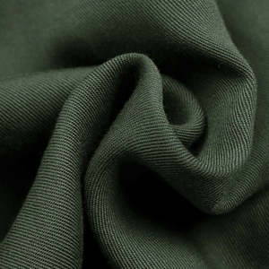 Macro shot of dark green knitted fabric showing detailed texture and soft material quality