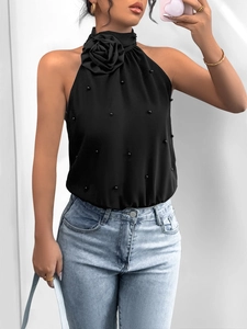 Detail of black halter bodysuit featuring a large 3D rose and delicate pearl embellishments