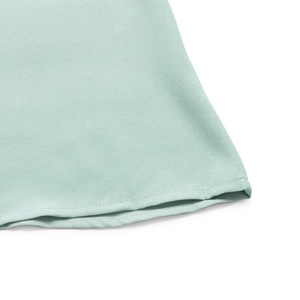 Gros plan détaillé de l'ourlet de la robe vert menthe avec couture et texture de tissu fines