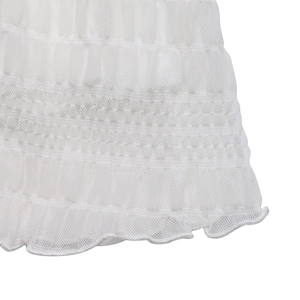 Detailed macro view of white pleated mesh fabric with delicate ruffles and hem texture
