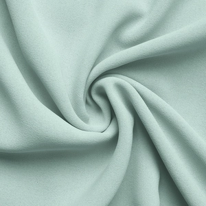 Détail du tissu vert menthe clair montrant une texture douce et des plis drapés