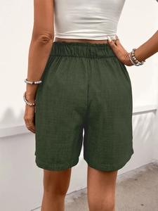 Detail der dunkelgrünen Shorts mit Leinentextur und elastischem hohem Bund mit Falten