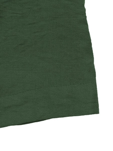 Gros plan sur le tissu vert foncé du short montrant la texture fine et les finitions soignées