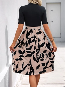 Détail de la robe mi-longue patchwork avec ceinture nouée et motif de feuilles abstrait
