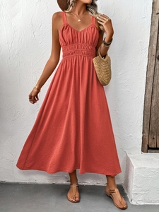 Détail de la robe longue orange corail avec texture froncée et col en V pour l'été