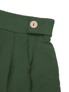 Détail de la taille haute en crêpe vert foncé avec une fermeture par bouton en bois naturel