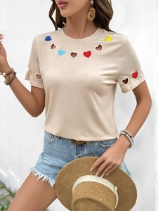 Détail de la broderie de cœur et de la découpe sur le t-shirt beige à manches courtes
