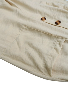 Detail of cream cotton linen fabric texture with patch pocket and tortoiseshell buttons