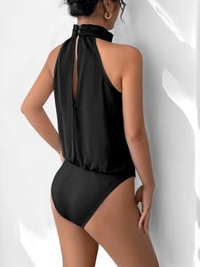 Detail view of black halter neck bodysuit featuring a back slit and button neck closure