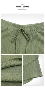 Detail of dark green textured shorts showing elastic drawstring waist and fabric texture