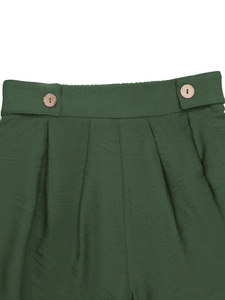 Détail de pantalon taille haute vert foncé avec boutons en bois et plis sophistiqués