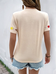 Vue arrière du t-shirt beige avec broderies cœur et découpes en forme de cœur aux manches