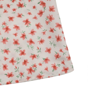 Vue macro du tissu à fleurs montrant les coutures de l'ourlet et la texture coton