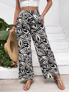 Detail view of high-waisted wide-leg pants featuring retro black and white floral paisley patterns