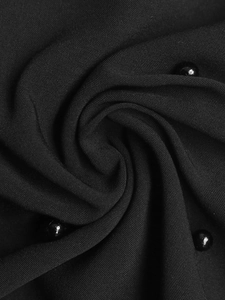 Macro shot of black mesh fabric with 3D floral beadwork detailing and texture