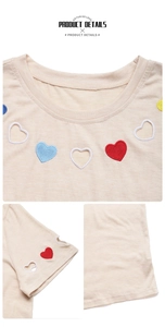 Vue détaillée des broderies de cœurs colorés et motifs ajourés sur le t-shirt beige à manches
